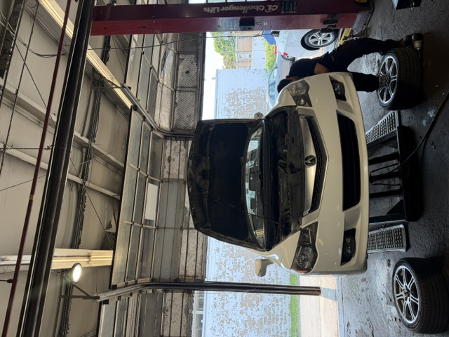 White vehicle with wheels off for tire and brake service
