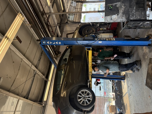 Grey vehicle on the lift being inspected